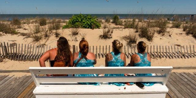Vacationers from Pittsburgh, Pennsylvania watch the ocean from the boardwalk in Rehoboth Beach, Delaware, Sunday, June 19, 2022. 