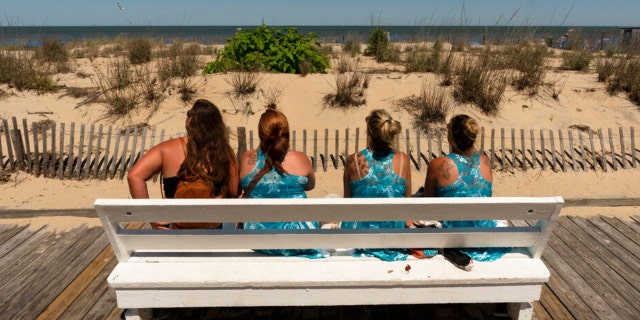 Vacationers from Pittsburgh, Pennsylvania watch the ocean from the boardwalk in Rehoboth Beach, Delaware, Sunday, June 19, 2022.