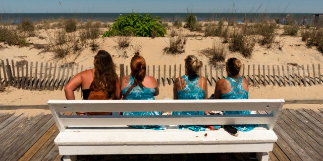 Vacationers from Pittsburgh, Pa., watch the ocean from the boardwalk in Rehoboth Beach, Del., Sunday, June 19, 2022. 