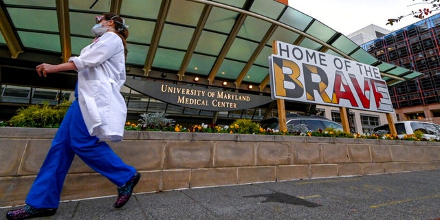 A doctor passes in front of University of Maryland Medical Center in Baltimore, Dec. 11, 2020. 