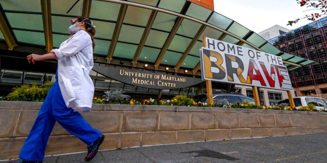 A doctor passes in front of University of Maryland Medical Center in Baltimore, Dec. 11, 2020. 