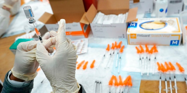 FILE - A Northwell Health registered nurse fills a syringe with a COVID-19 vaccine at a pop up vaccination site the Albanian Islamic Cultural Center, April 8, 2021, in the Staten Island borough of New York. 
