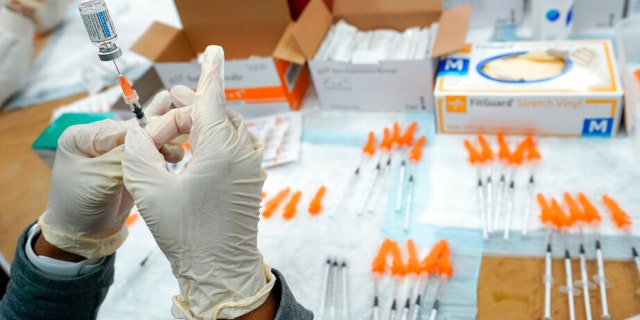 FILE - A Northwell Health registered nurse fills a syringe with a COVID-19 vaccine at a pop up vaccination site the Albanian Islamic Cultural Center, April 8, 2021, in the Staten Island borough of New York.