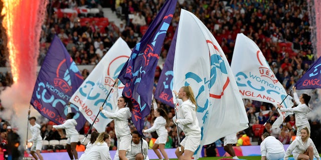 Girls wave flags on the pitch during the opening ceremony before the Women Euro 2022 opening soccer match between England and Austria at Old Trafford in Manchester, England, Wednesday, July 6, 2022.