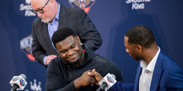 New Orleans Pelicans forward Zion Williamson shakes hands with New Orleans Pelicans head coach Willie Green with New Orleans Pelicans vice president of basketball operations David Griffin standing in the background after talking to the media about signing his contract extension at the Dryades YMCA in New Orleans, Wednesday, July 6, 2022.