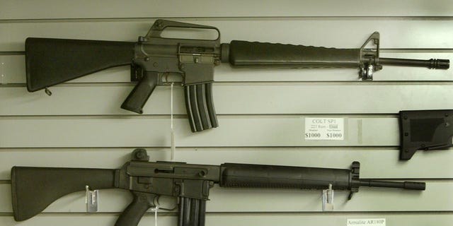 Assault-style rifles hang on display inside a Dallas, Texas gun shop, September 13, 2004.