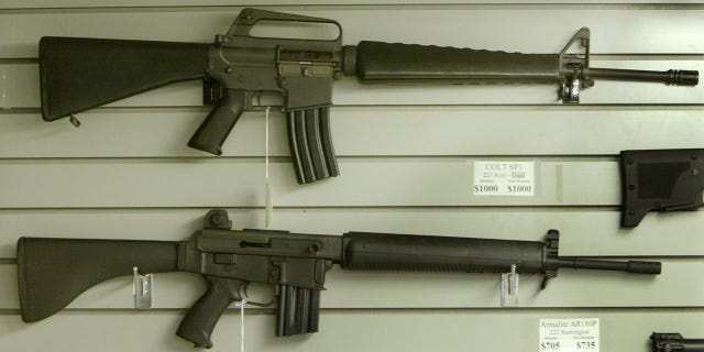 Assault-style rifles hang on display inside a Dallas, Texas gun shop, September 13, 2004.