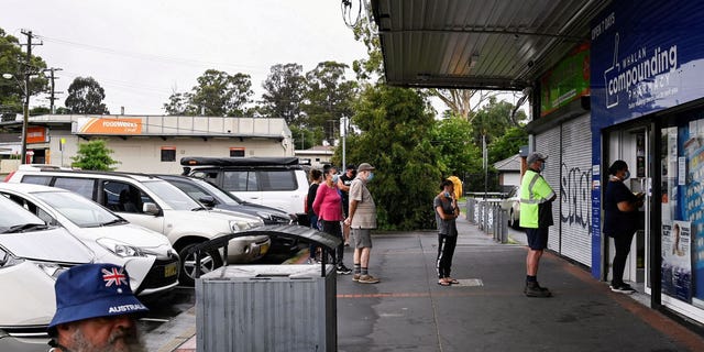 Customers queue outside a Western Sydney chemist to purchase Rapid Antigen Test kits in the wake of the COVID-19 pandemic in Sydney, Australia, on Jan. 5, 2022.  