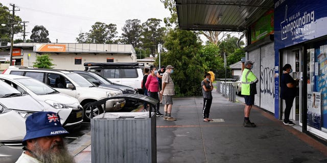 Customers queue outside a Western Sydney chemist to purchase Rapid Antigen Test kits in the wake of the COVID-19 pandemic in Sydney, Australia, on Jan. 5, 2022.