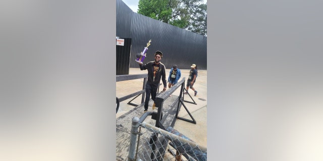 Antoine Miller hoists the group's first-place trophy from the Atlanta competition in May 2022.