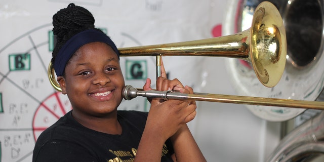 Sounds of Success member Ja'Niyah Johnson plays a trombone.