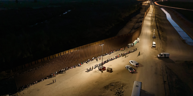 Aerial view of immigrants waiting to be processed by the U.S. Border Patrol after crossing the border from Mexico on June 23, 2022 in Yuma, Arizona.