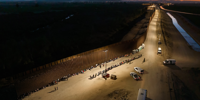 Aerial view of immigrants waiting to be processed by the U.S. Border Patrol after crossing the border from Mexico on June 23, 2022 in Yuma, Arizona.