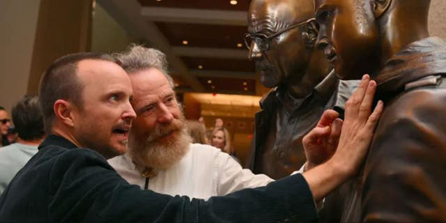 ALBUQUERQUE, NEW MEXICO - JULY 29: Actor Aaron Paul (L) and actor Bryan Cranston examine bronze statues depicting television characters Walter White, played by Cranston, and Jesse Pinkman, played by Paul, from the series "Breaking Bad" at the Albuquerque Convention Center on July 29, 2022 in Albuquerque, New Mexico. (Photo by Sam Wasson/Getty Images)