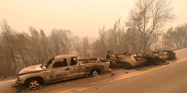 A burned pickup truck and a trailer in the middle of state Highway 96 were destroyed by the McKinney Fire in Klamath River, California, Saturday, July 30, 2022.