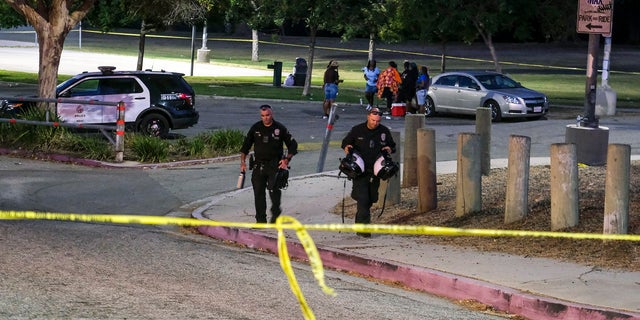 Police officers leave the scene of a shooting at Peck Park in San Pedro, Calif., Sunday, July 24, 2022. 