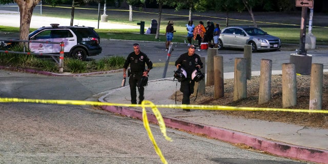 Police officers leave the scene of a shooting at Peck Park in San Pedro, Calif., Sunday, July 24, 2022.