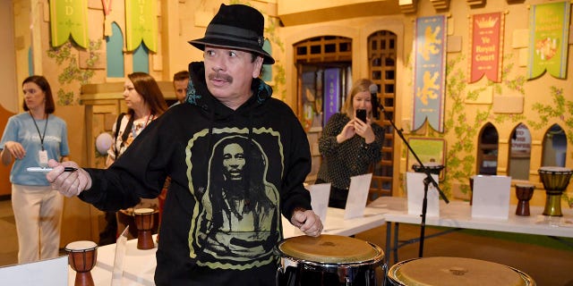 Recording artist Carlos Santana autographs congas that he and his wife Cindy Blackman Santana donated to the Las Vegas Philharmonic while participating in the Philharmonic's global edition of the orKIDStra music education program for a group of students at the Discovery Children's Museum on October 29, 2019 in Las Vegas, Nevada.