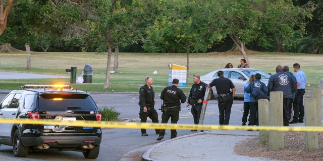 Police officers stand near the scene of a shooting at Peck Park in San Pedro, Calif., Sunday, July 24, 2022.