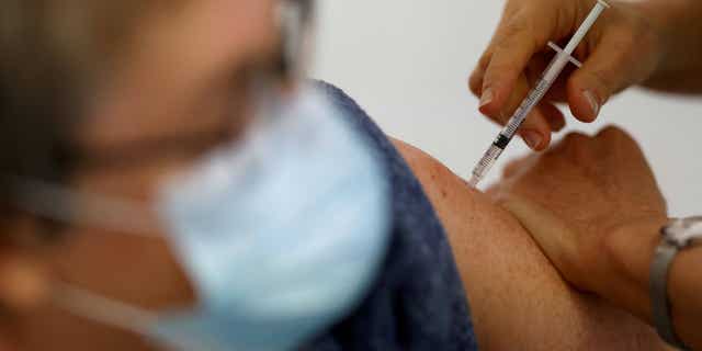 A nurse administers a COVID-19 vaccine to a patient at a vaccination center in November 2021.