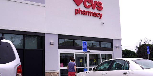 A customer walks into a CVS Pharmacy store, Tuesday, Aug. 3, 2021, in Woburn, Mass.