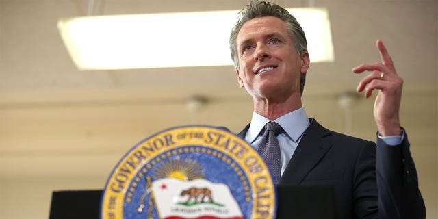 California Governor Gavin Newsom behind a podium with CA seal
