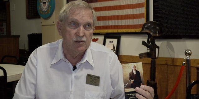 Dave Giles, a candidate in the Republican primary for Arizona's 4th District, waves a pocket Constitution.