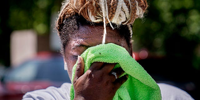 Nicole Brown wipes sweat from her face while setting up her beverage stand near the National Mall on Friday, July 22, 2022, in Washington.