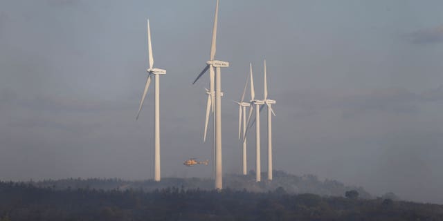 A helicopter tackles a fire at the Valmediano eolic park, following the wildfires across the province of Zamora, on the second heatwave of the year, in Spain, July 19, 2022.