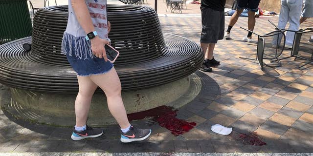 Blood pooled at Port Clinton Square in Highland Park, after a shooting at a July Fourth parade, in a Chicago suburb, Monday, July 4, 2022. (Lynn Sweet/Chicago Sun-Times via AP)