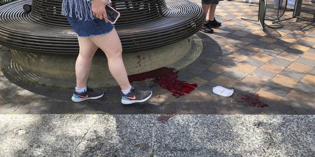 Blood pooled at Port Clinton Square in Highland Park, after a shooting at a July Fourth parade, in a Chicago suburb, Monday, July 4, 2022. (Lynn Sweet/Chicago Sun-Times via AP)