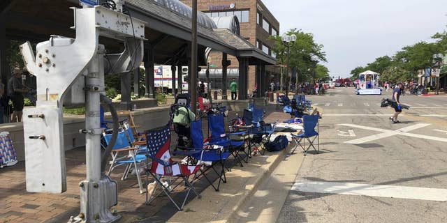 Empty chairs sit along the sidewalk after parade-goers fled Highland Park's Fourth of July parade after shots were fired, Monday, July 4, 2022 in Chicago. (Lynn Sweet/Chicago Sun-Times via AP)