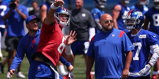 Quarterback Daniel Jones #8 of the New York Giants throws a pass as head coach Brian Daboll, right, looks on during mandatory minicamp at Quest Diagnostics Training Center on June 8, 2022 in East Rutherford, New Jersey. 