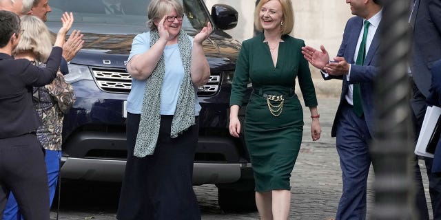 Britain's Secretary of State for Foreign, Commonwealth and Development Affairs, Liz Truss receives applause from her team near Parliament in London, Wednesday, July 20, 2022. 