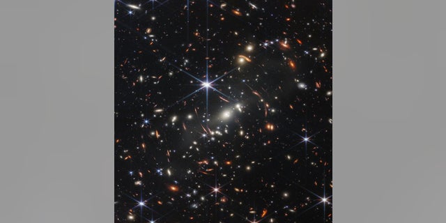 The first released Monday from the James Webb Space Telescope shows galaxies around each other whose light has been bent, NASA officials said.