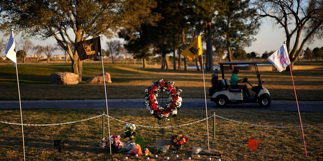 A golfer drives by a makeshift memorial at the Rockwind Community Links, on March 16, 2022, in Hobbs, New Mexico. The memorial was for student golfers and the coach of University of the Southwest killed in a crash in Texas.
