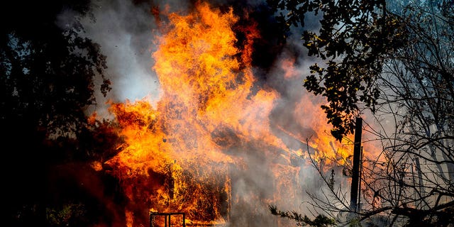 Flames from the Oak Fire consume a home on Triangle Road in Mariposa County, Calif., Saturday, July 23, 2022. 