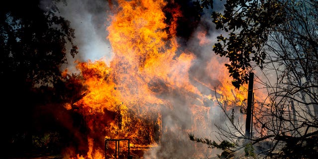 Flames from the Oak Fire consume a home on Triangle Road in Mariposa County, Calif., Saturday, July 23, 2022. 