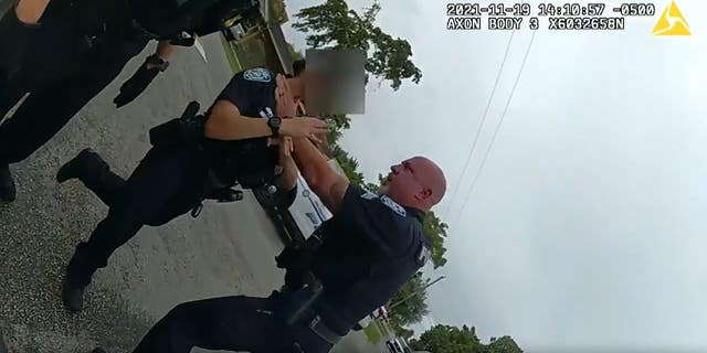 Sgt. Christopher Pullease grabs a fellow police officer by the neck.