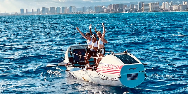Lat35 rowers Libby Costello, Sophia Denison-Johnston, Brooke Downes and Adrienne Smith cheer at the finish line of the Great Pacific Race in Waikiki, Hawaii, on July 25, 2022.