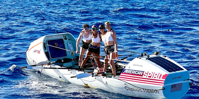 Lat35 rowers Libby Costello, Sophia Denison-Johnston, Brooke Downes and Adrienne Smith pose at the finish line of the Great Pacific Race on July 25, 2022 in Waikiki, Hawaii.