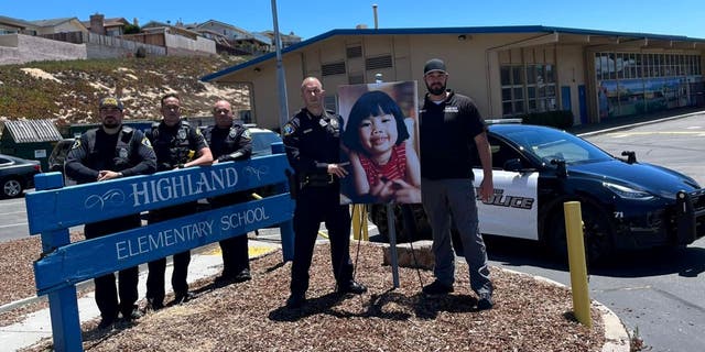 Miembros del Departamento de Policía de Seaside junto a la foto de Anne Pham