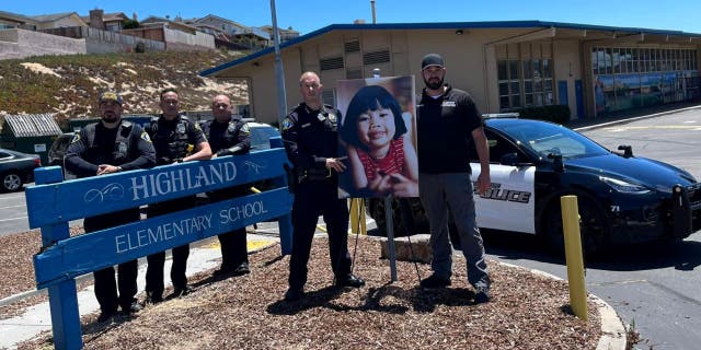 Members of the Seaside Police Department stand next to photo of Anne Pham