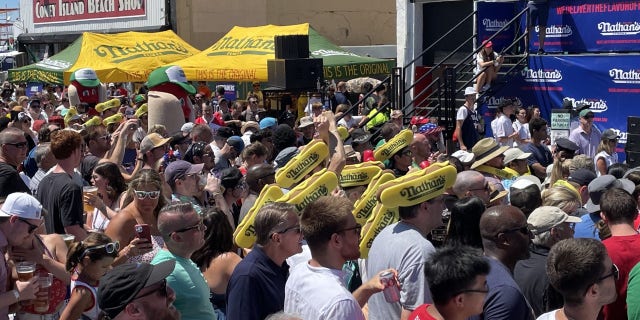 Una multitud se reúne para ver el famoso concurso de comer perritos calientes de Nathan en Coney Island el 4 de julio de 2022. 