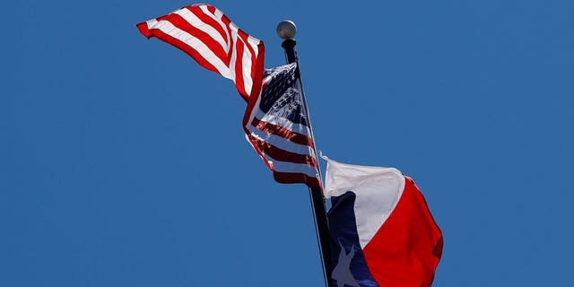 Bendera AS dan bendera Texas State berkibar di atas Texas State Capitol