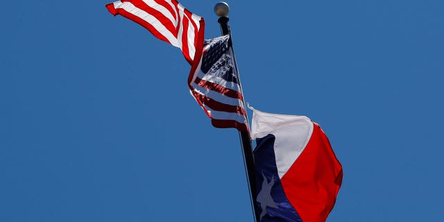 Bendera AS dan bendera Texas State berkibar di atas Texas State Capitol