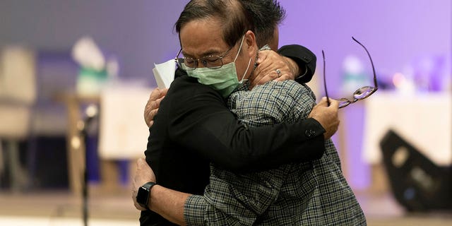 Jason Aguilar, left, a senior pastor at Arise Church, comforts Billy Chang, a 67-year-old Taiwanese pastor who survived Sunday's shooting at Geneva Presbyterian Church, during a prayer vigil in Irvine, Calif., Monday, May 16, 2022. A gunman opened fire on May 15 during a luncheon at Geneva Presbyterian Church, killing one and injuring five other members of a Taiwanese congregation that met there. 