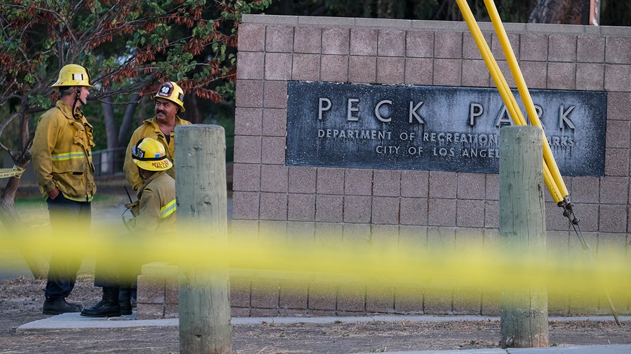A photo of firefighters near the Peck Park sign.