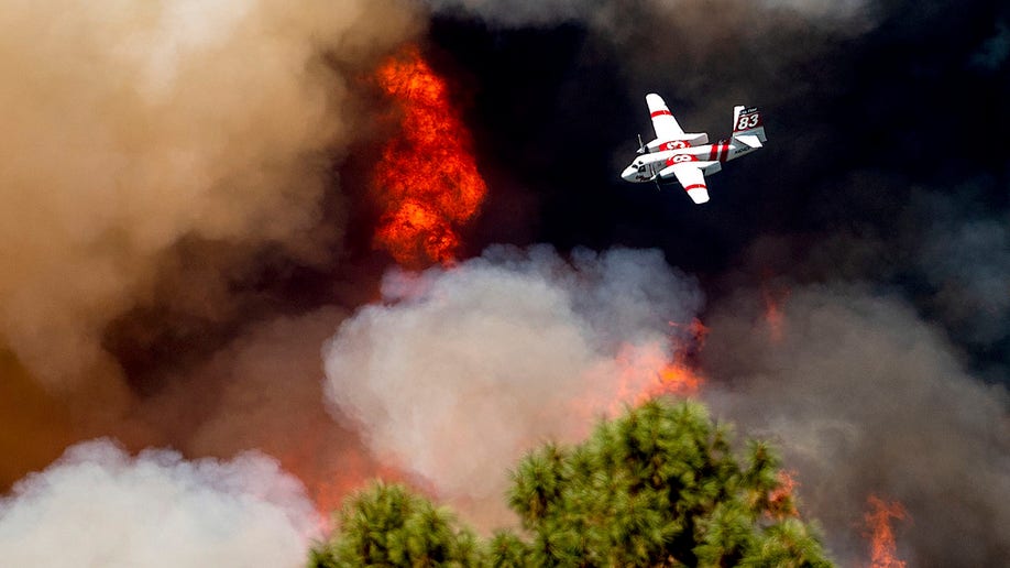 Air tanker flying over burning forest