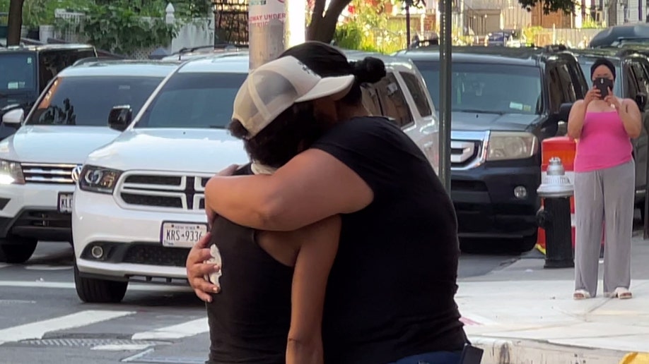 Two people embrace at the scene of the fatal stabbing of Nathaniel Rivers on Decatur Ave. in the Bronx on July 21